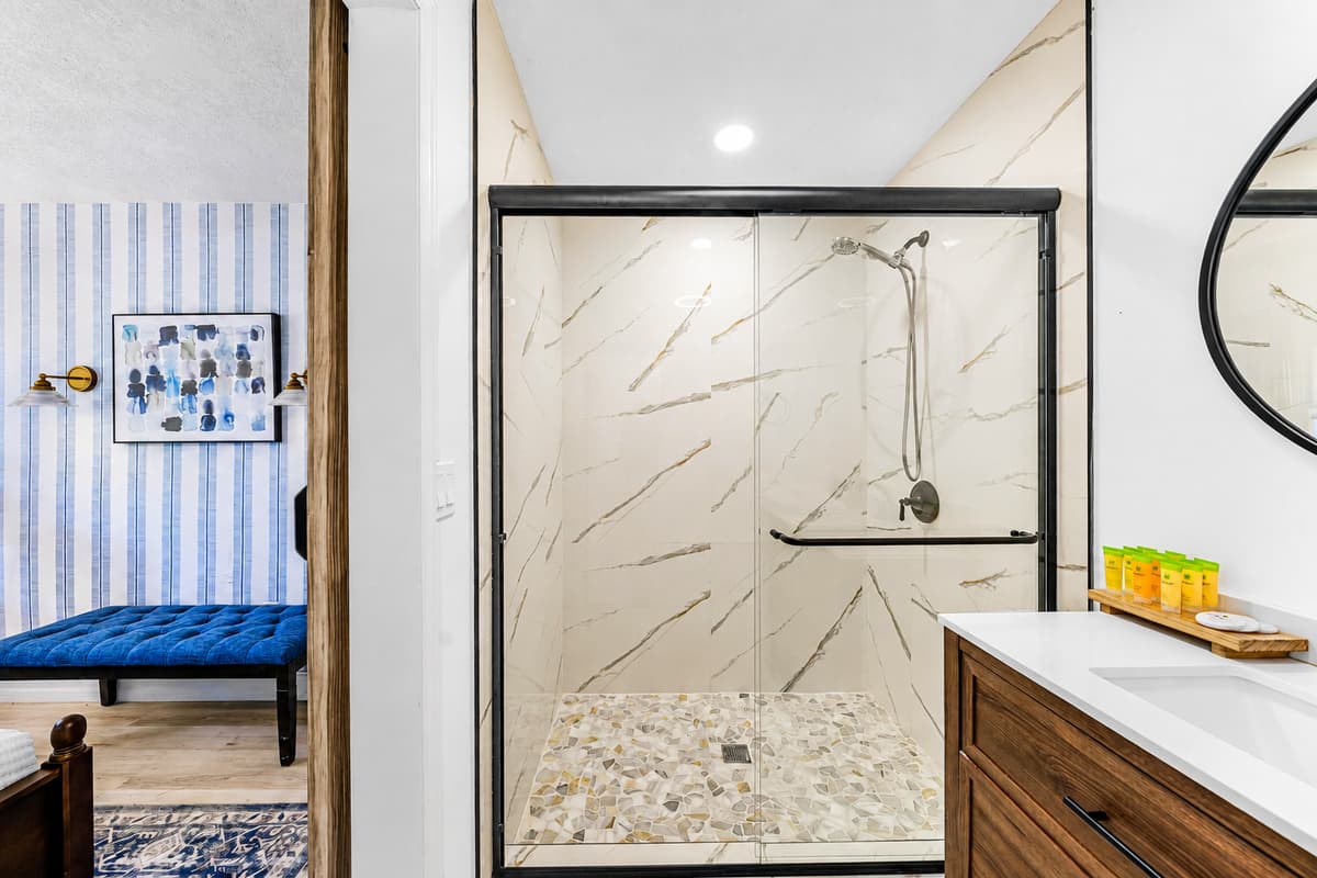 Sliding glass door, no lip to step over, tile floor to ceiling. Easy in, easy out, easy to clean.