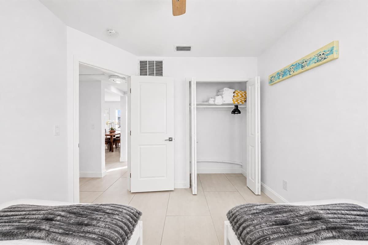 Spacious twin bedroom with closet storage and convenient access to the hallway.