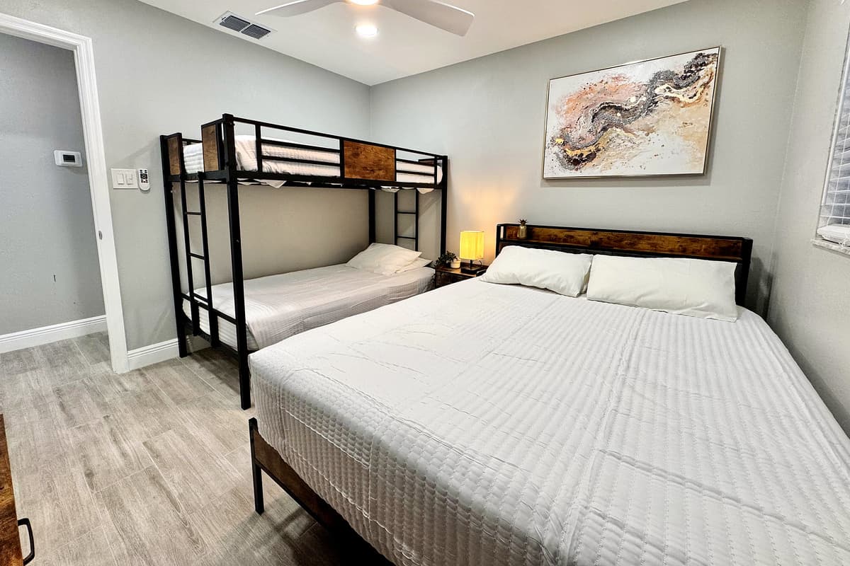 This bedroom features a queen-size bed and a bunk bed, offering flexible sleeping arrangements perfect for families or groups.