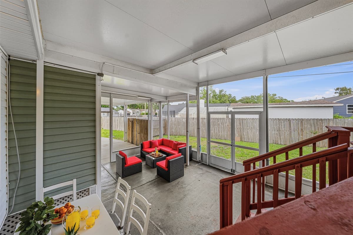 Elevated view of the spacious screened patio with comfortable seating and backyard views.