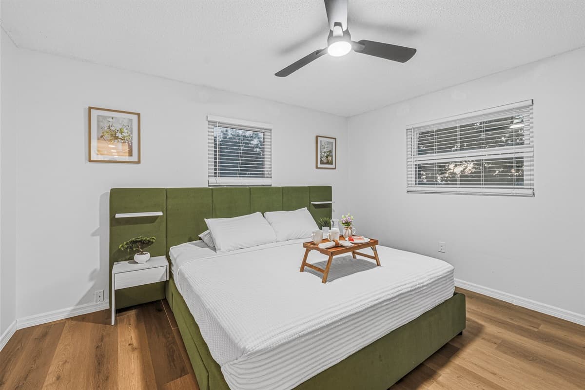 Comfortable king bedroom with clean design, ample natural light, and relaxing ambiance 