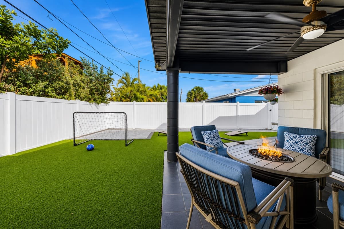 Backyard patio view featuring the fire table lounge area and outdoor recreation space.