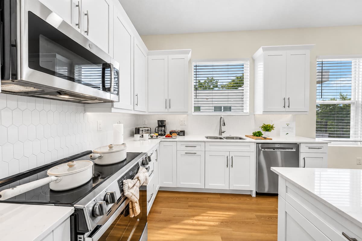 Pots and pans included. Bring an appetite. The kitchen comes stocked with cookware, utensils, and the basics to make real meals. Hexagon tile, a stainless range, and bright cabinets make cooking feel like a hobby, not a chore.