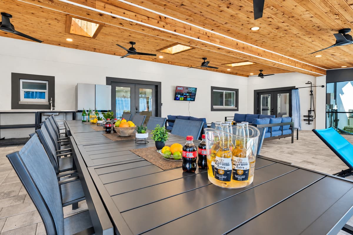 One table long enough for everyone, with the pool glowing behind it.
