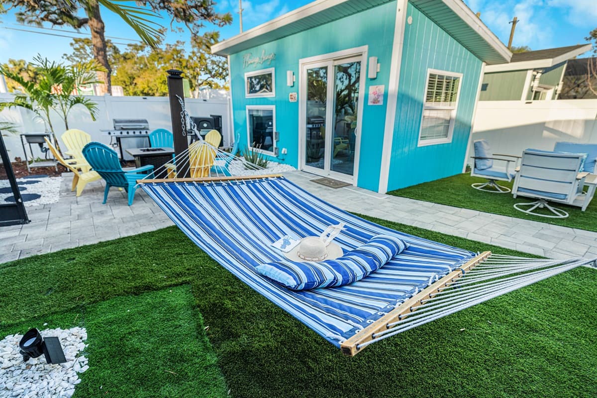 The flamingo lounge features Adirondack chairs, outdoor seating, and sliding glass doors, offering a seamless indoor-outdoor living experience.