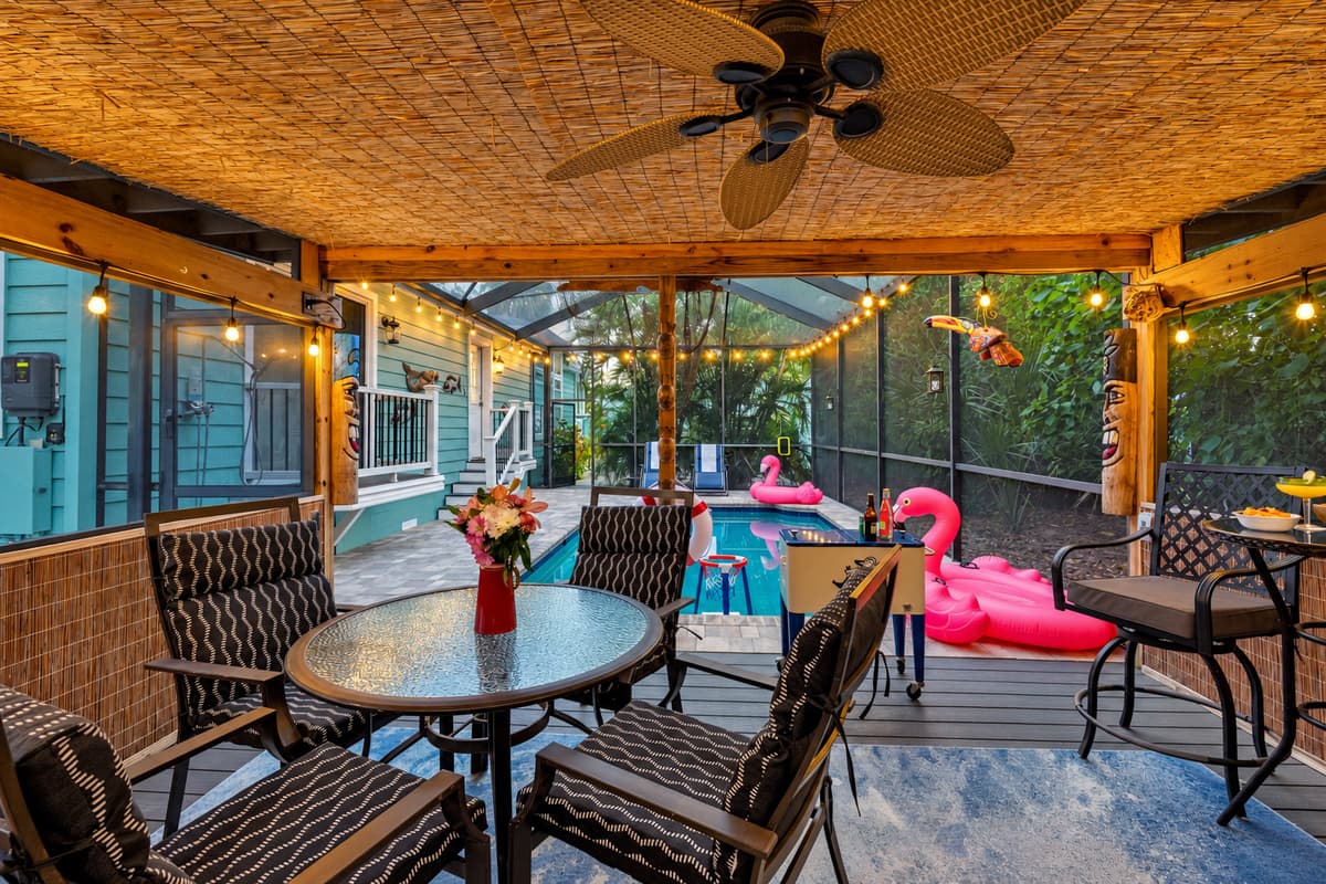 This tropical-themed patio is a guest favorite! Featuring a covered lounge area with plenty of seating, outdoor TV, fun tiki décor, and a bar setup.