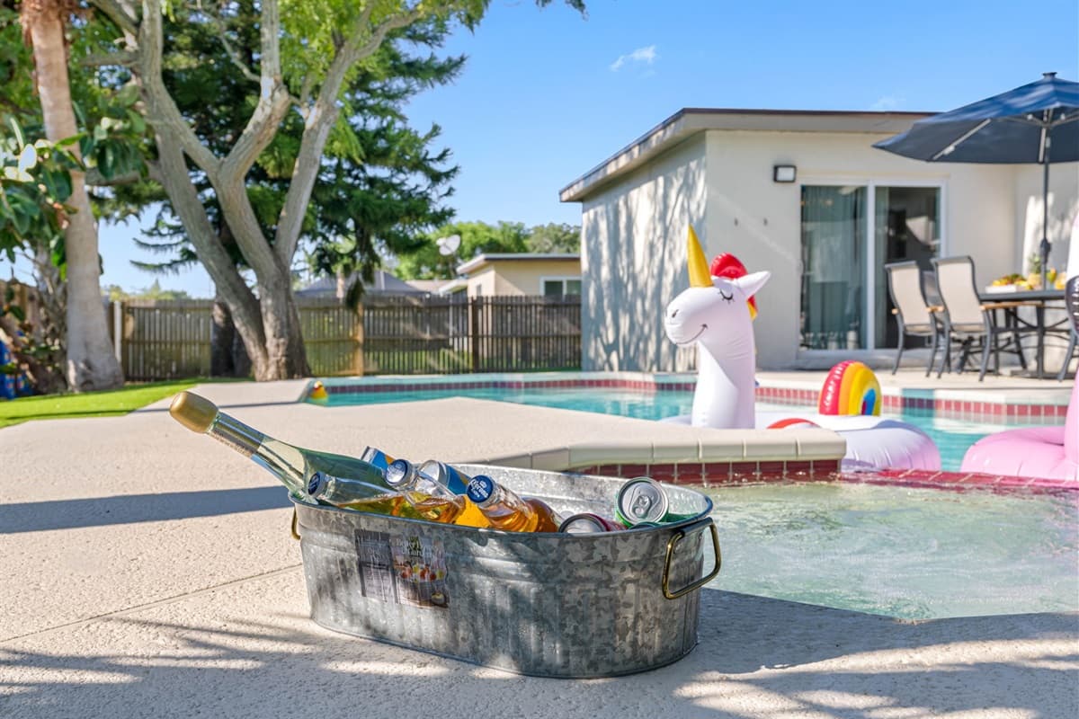 The pool itself is a sparkling oasis of cool, crystal-clear water, perfect for a refreshing dip on a warm day.
