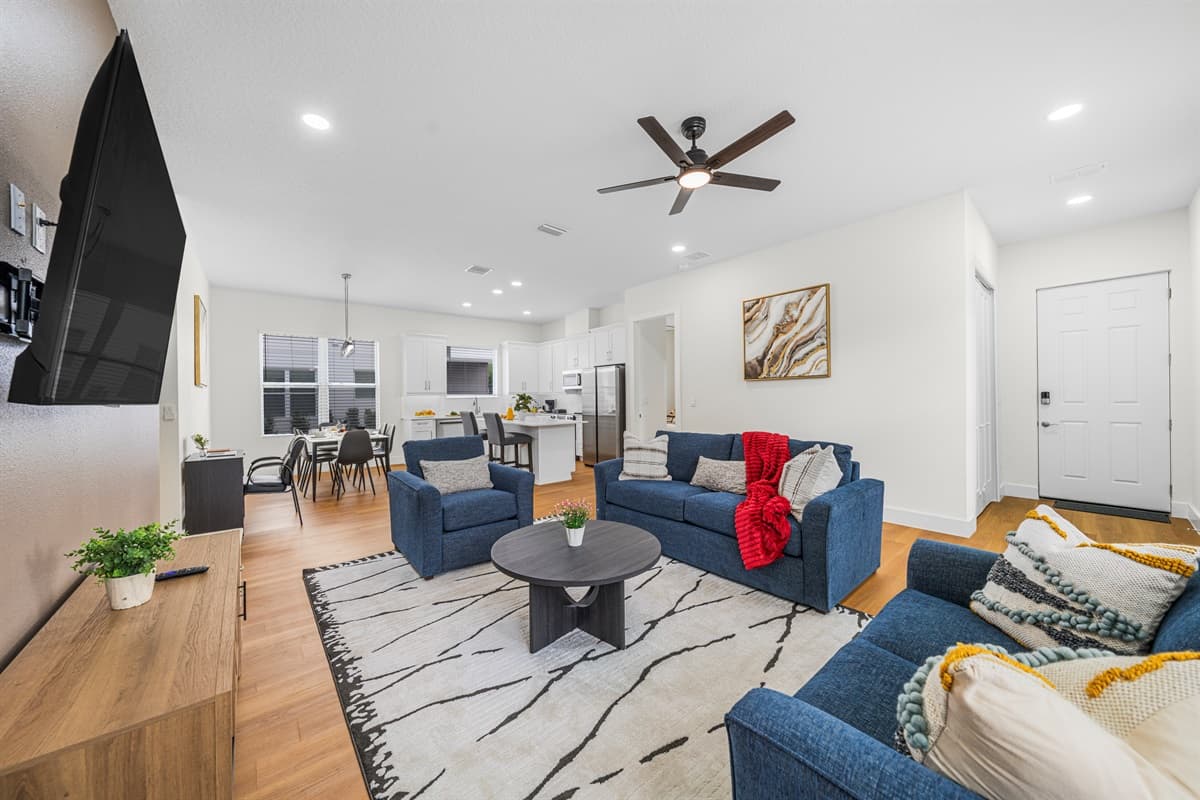 Spacious living room with cozy seating, large TV, and contemporary décor for relaxing.