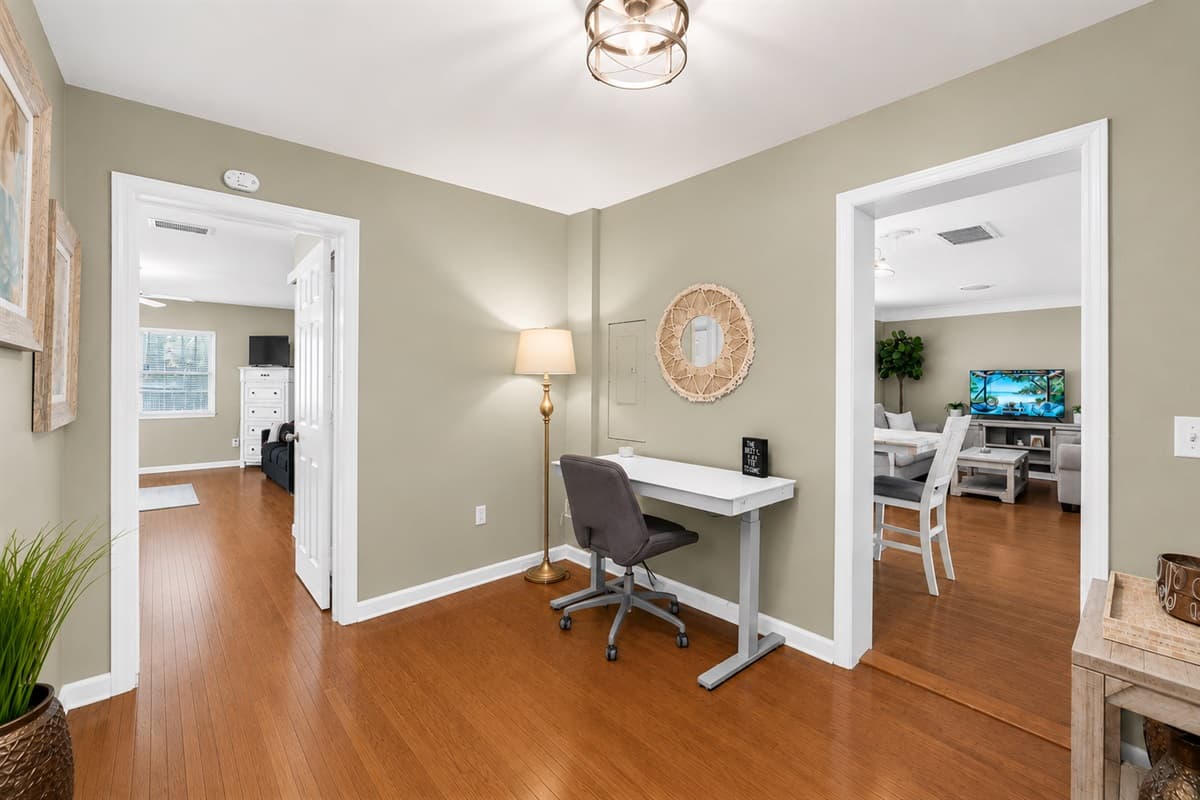 Spacious common area featuring a home office setup and easy access to the dining room.