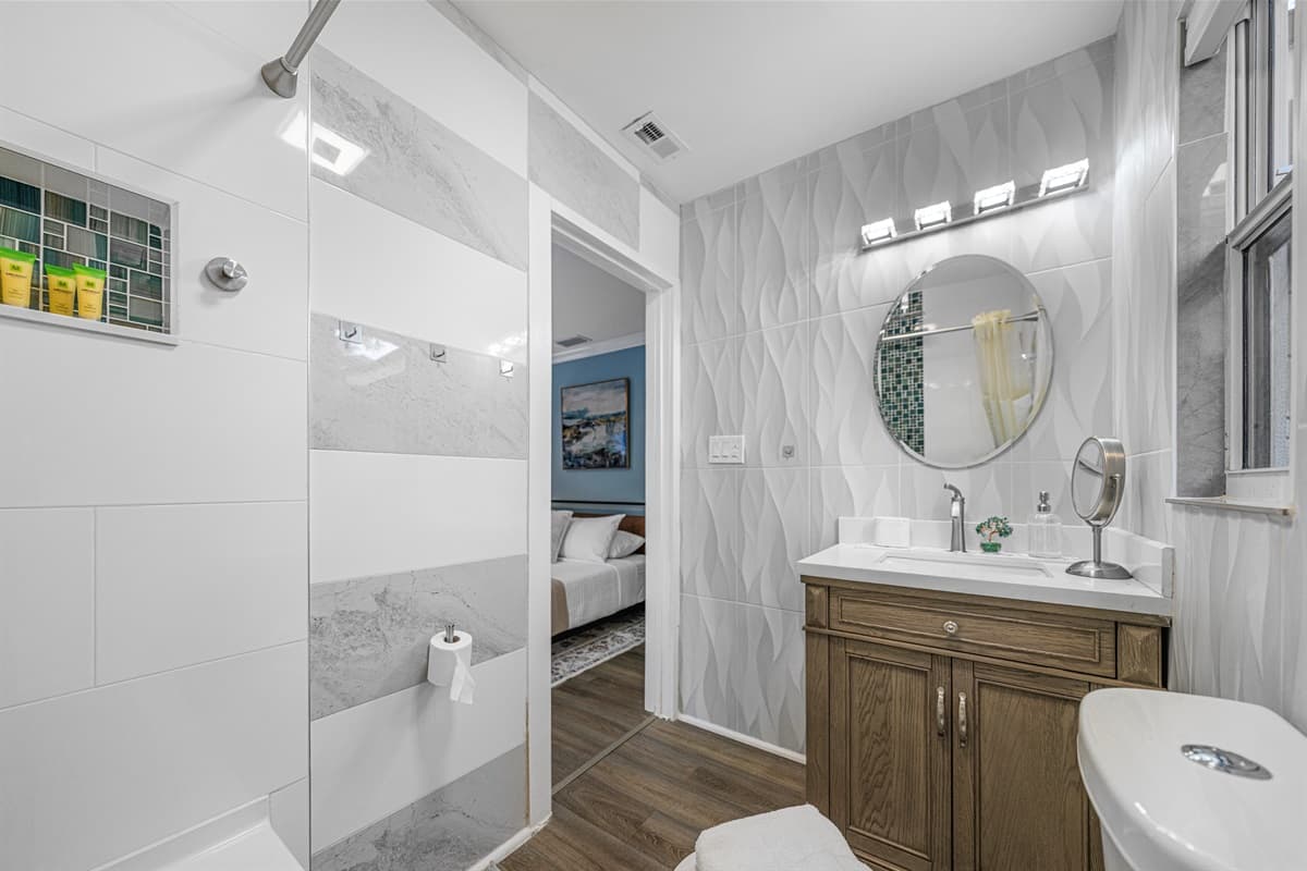 Enjoy a beautifully updated bathroom with a sleek vanity, contemporary fixtures, and plenty of light.