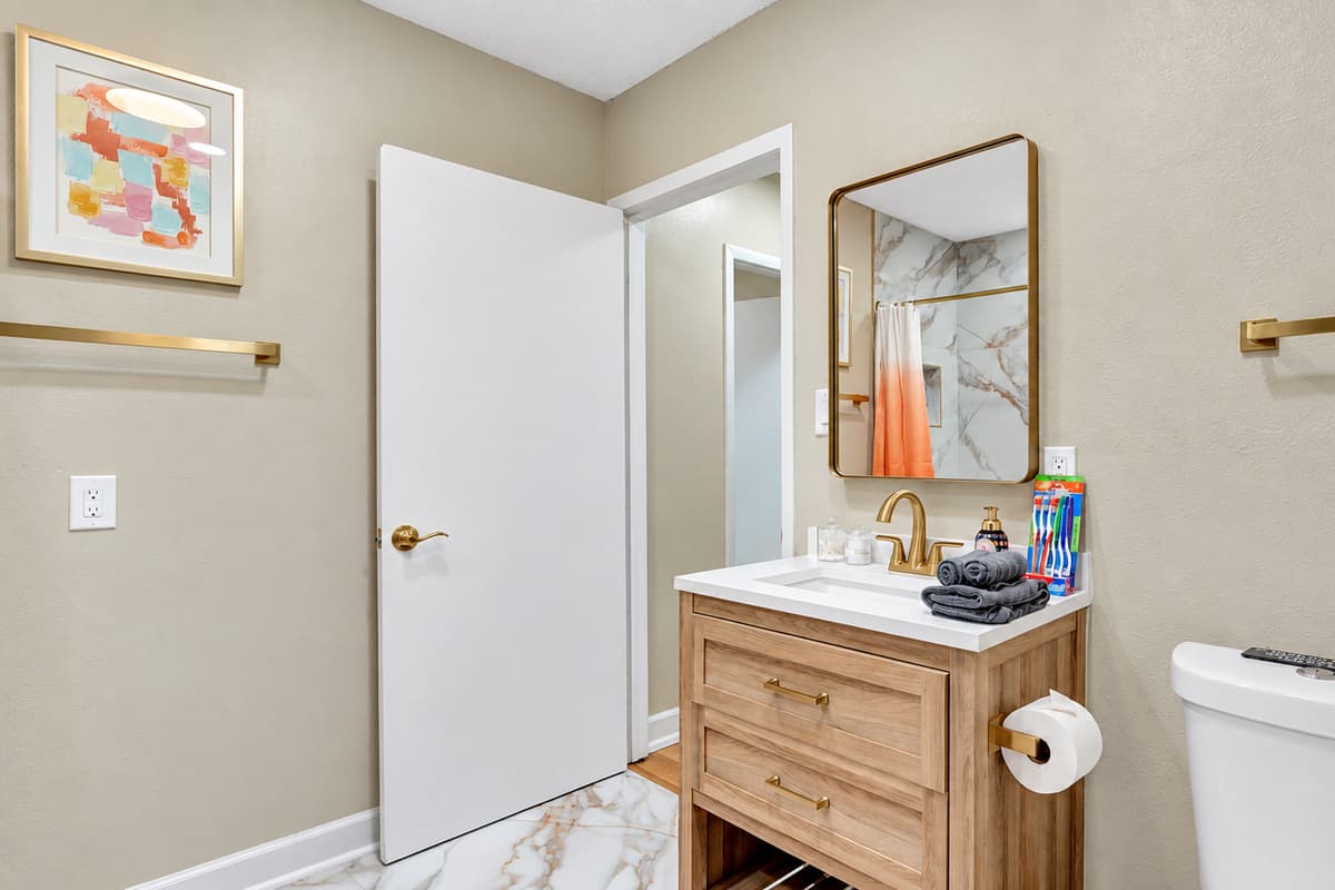 Elevate your stay to a golden standard of luxury in this lavish bathroom retreat.