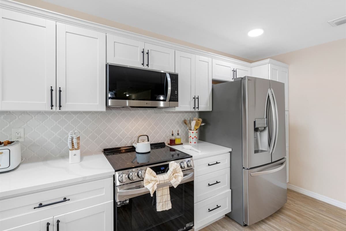 Enjoy cooking in this bright kitchen featuring a gas range, stainless steel fridge, and plenty of prep space.