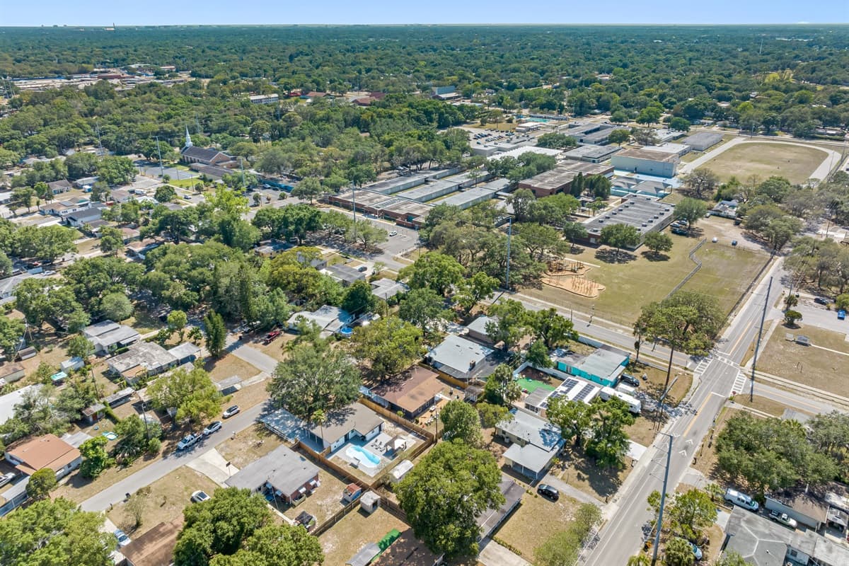 A tranquil community unfolds beneath you. Neatly arranged streets are lined with well-kept homes