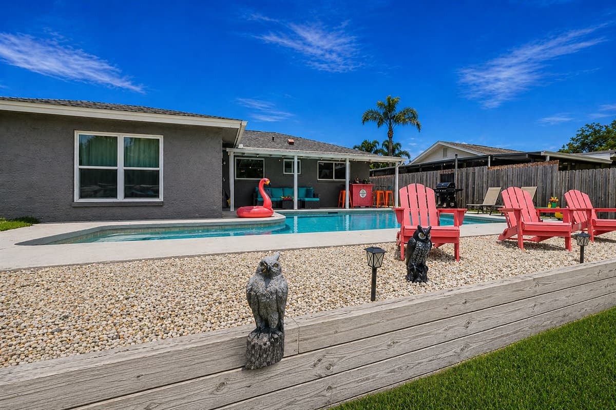 Elevated pool deck with Adirondack chairs overlooking the backyard oasis.