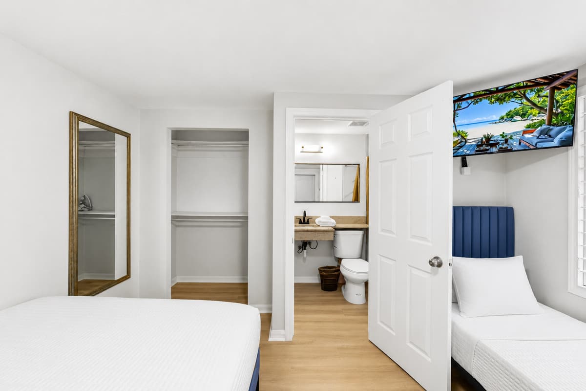 This thoughtfully designed connected bedroom suite comfortably accommodates multiple guests. The first room features one queen-size bed, while the connecting room offers a queen-size bed, a twin bed, and a private ensuite bathroom.