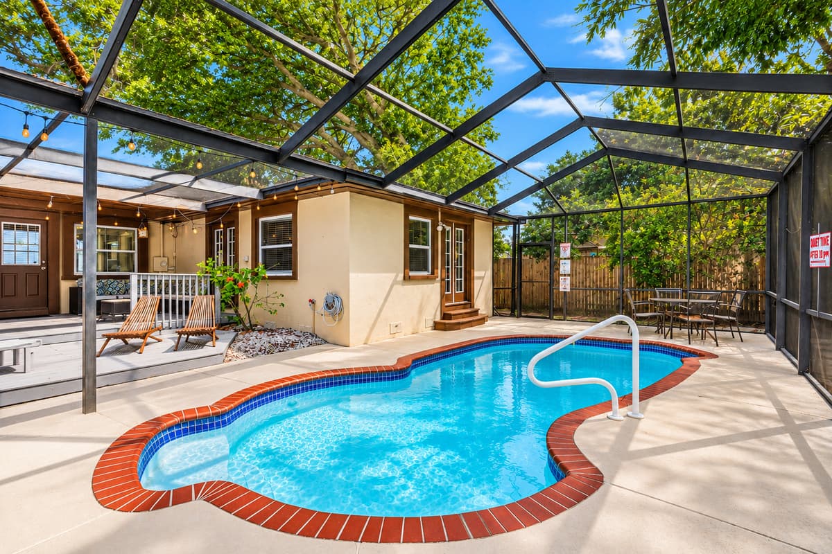 Resort-style pool area with a spacious screened enclosure and comfortable lounging spaces.