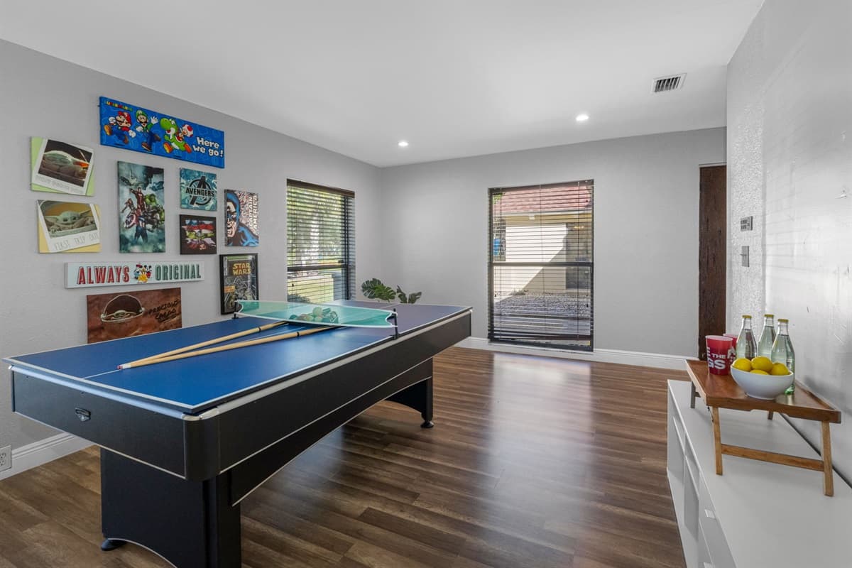 A bright and welcoming game room featuring a combo pool and ping pong table — great for friendly competition!