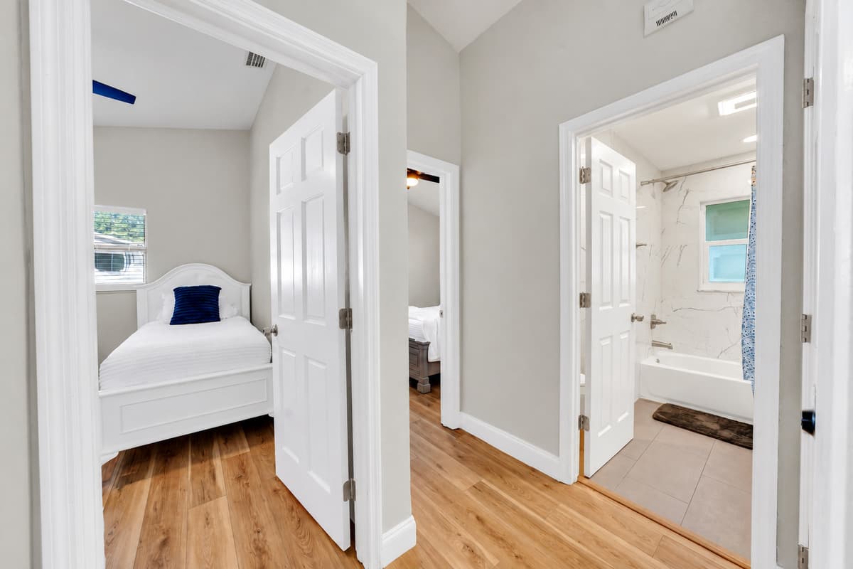 Bedrooms and a full bathroom on the same short hallway: no crossing the house at 2 AM, no queue in the morning. With nine people under one roof, the layout matters more than the square footage does.