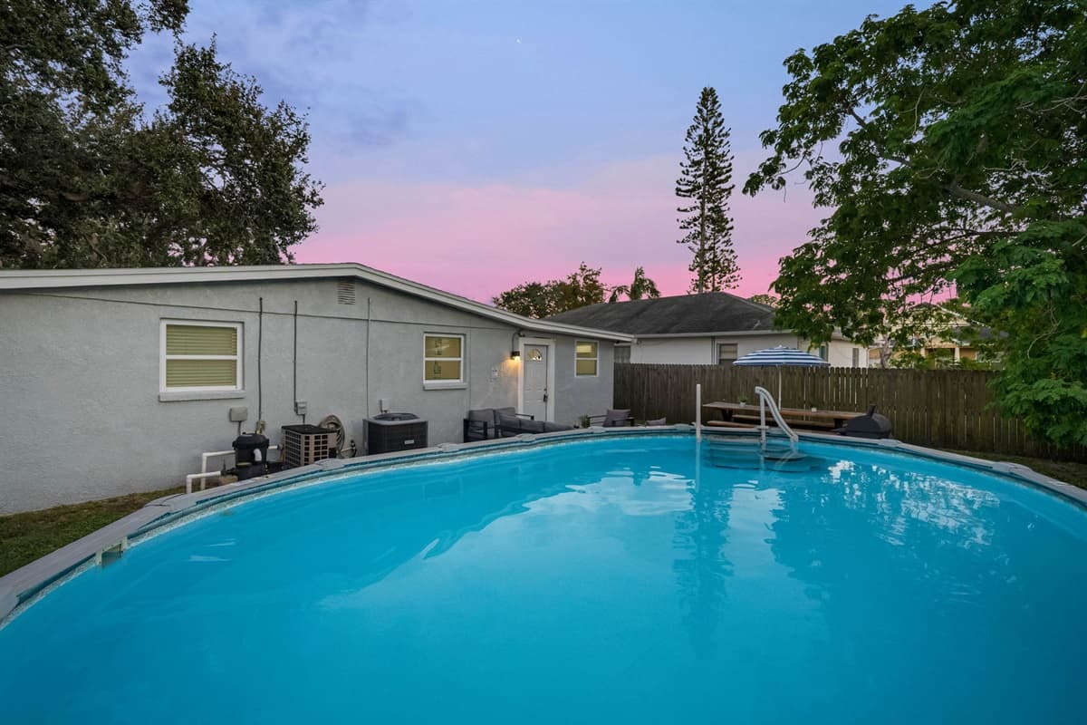 Enjoy a peaceful dip in this private above-ground pool under clear blue skies.