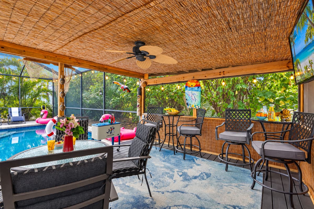 Enjoy the peaceful outdoor ambiance in this shaded patio retreat, complete with soft overhead lighting, gentle ceiling fan breezes, and lush natural surroundings.