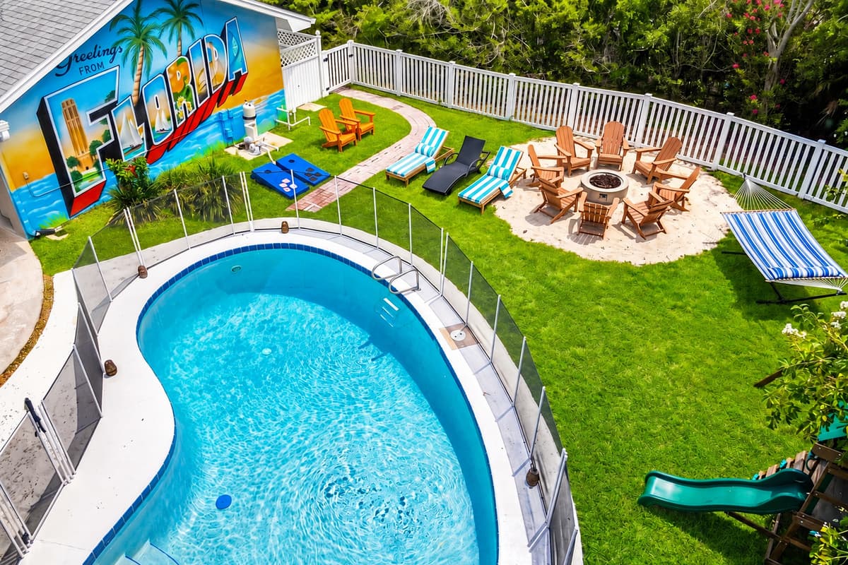 Curved pool, fire pit on the grass, chairs already circled. The afternoon and the evening are both handled.