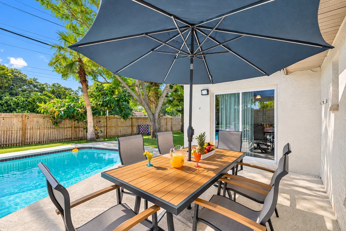 The dining area, perfectly positioned near the shimmering pool, offers an ideal setting for family meals or gatherings with friends.