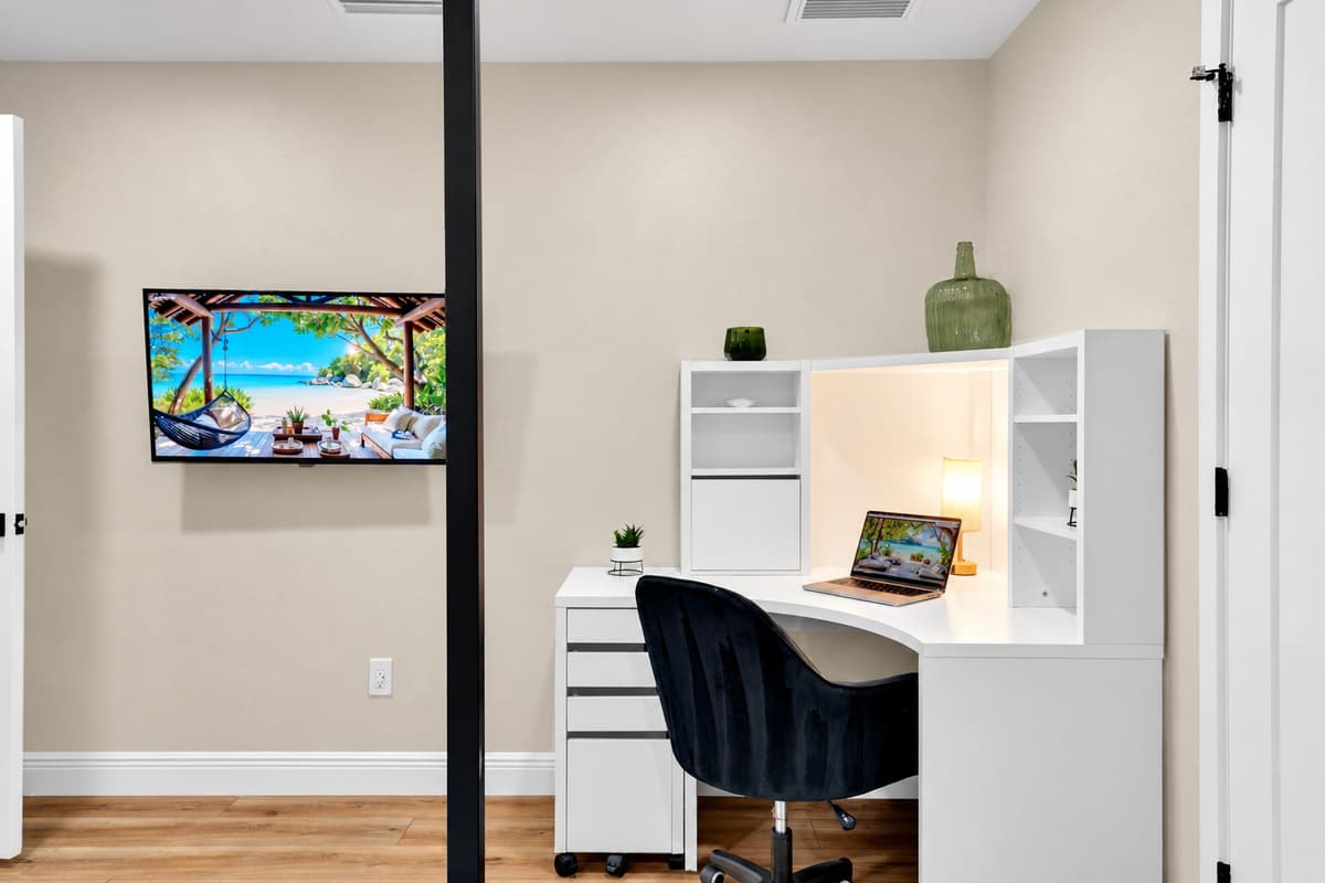 Take the call here, then take the rest of the day. A dedicated desk with shelving and a screen, tucked into a private corner — an hour of work at eight, and you're at the pool before anyone notices