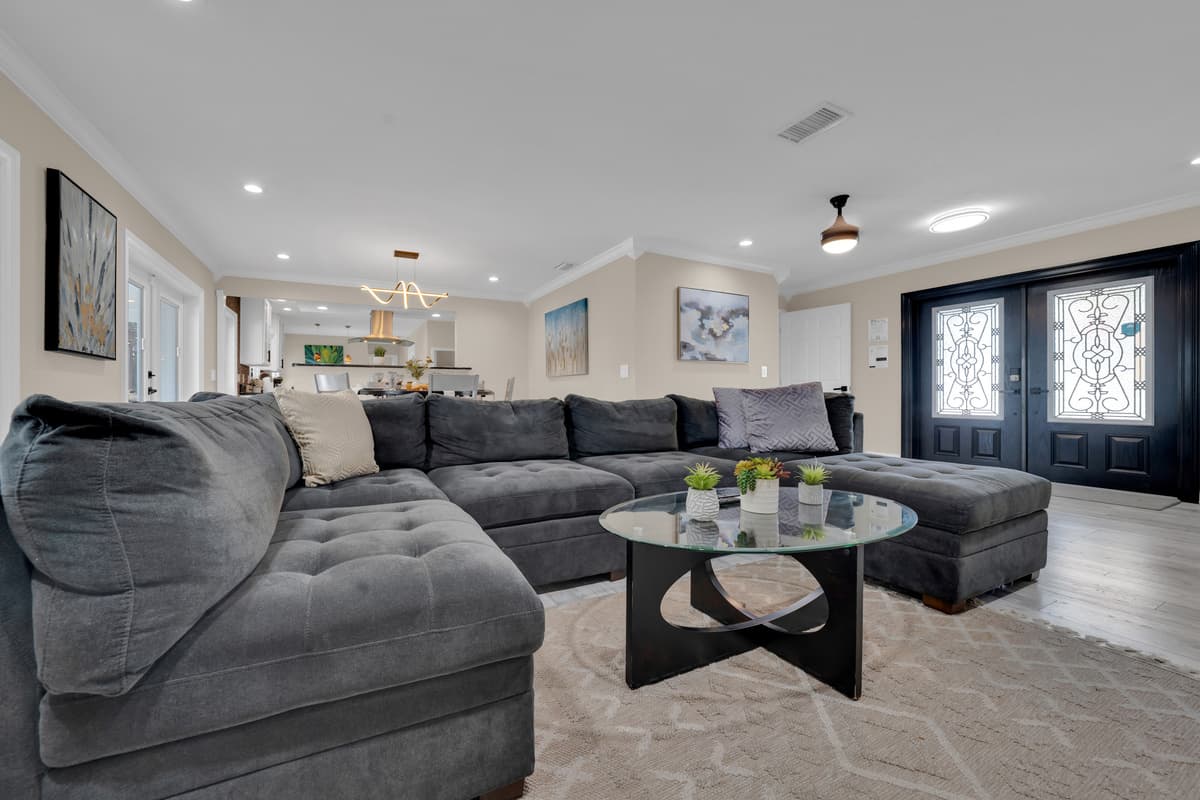 Natural light pours across the sectional sofa, creating an airy living room where everyone has a comfortable seat