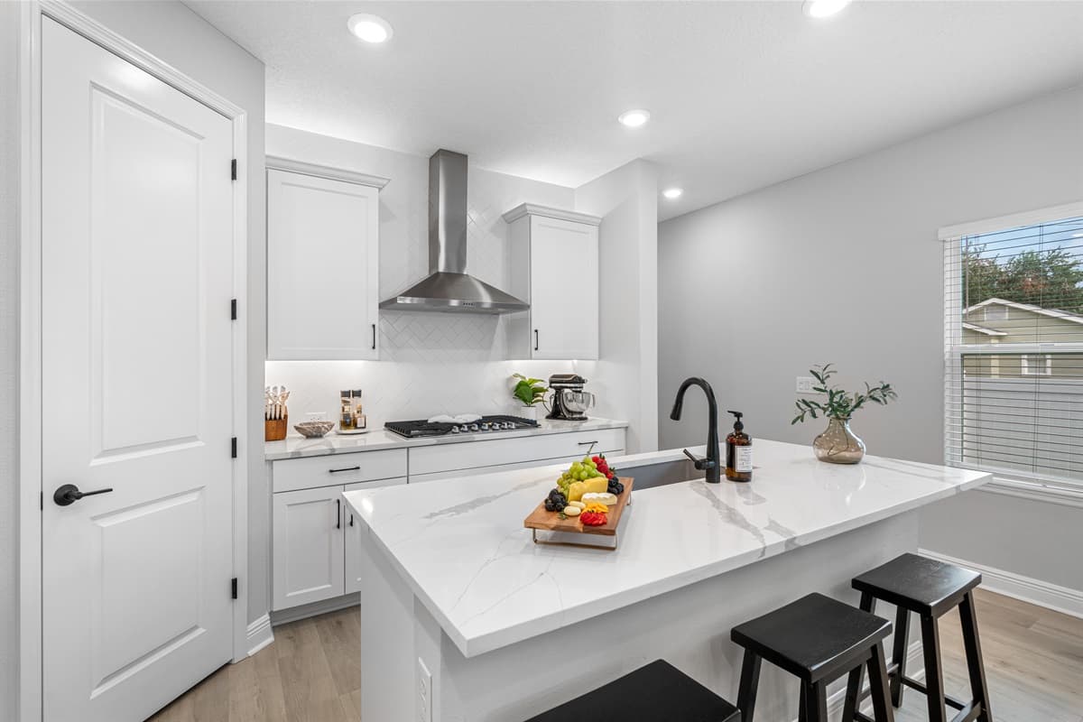 The sleek white cupboards are complemented by pristine white countertops, providing a clean and minimalist aesthetic that enhances the space's overall appeal.