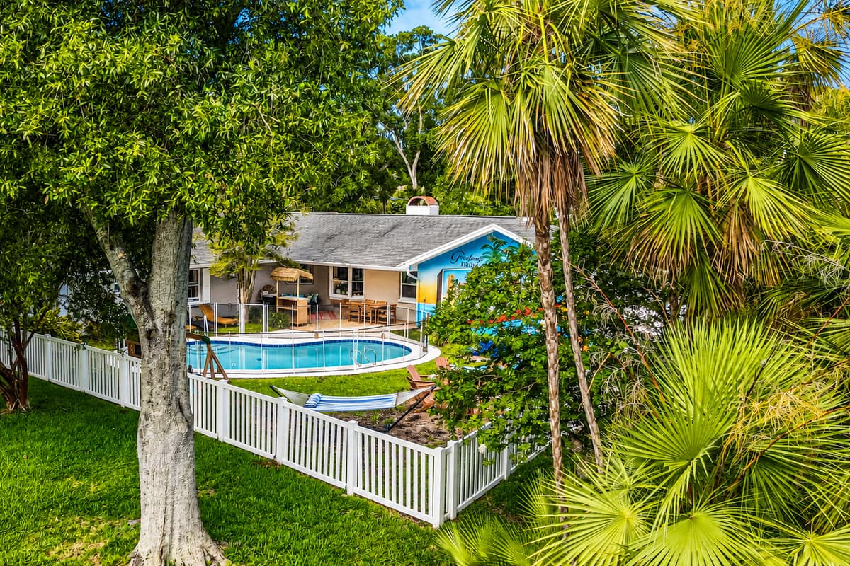From above: pool, patio, palms, and water behind the property line. Everything private, everything close.