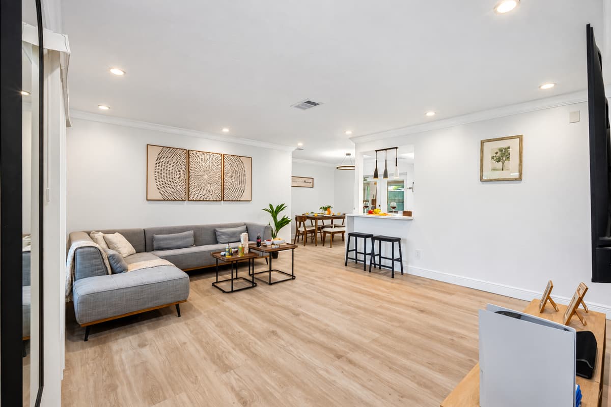 This open-concept living room is flooded with natural light and designed for relaxation, with thoughtful details and cozy touches.