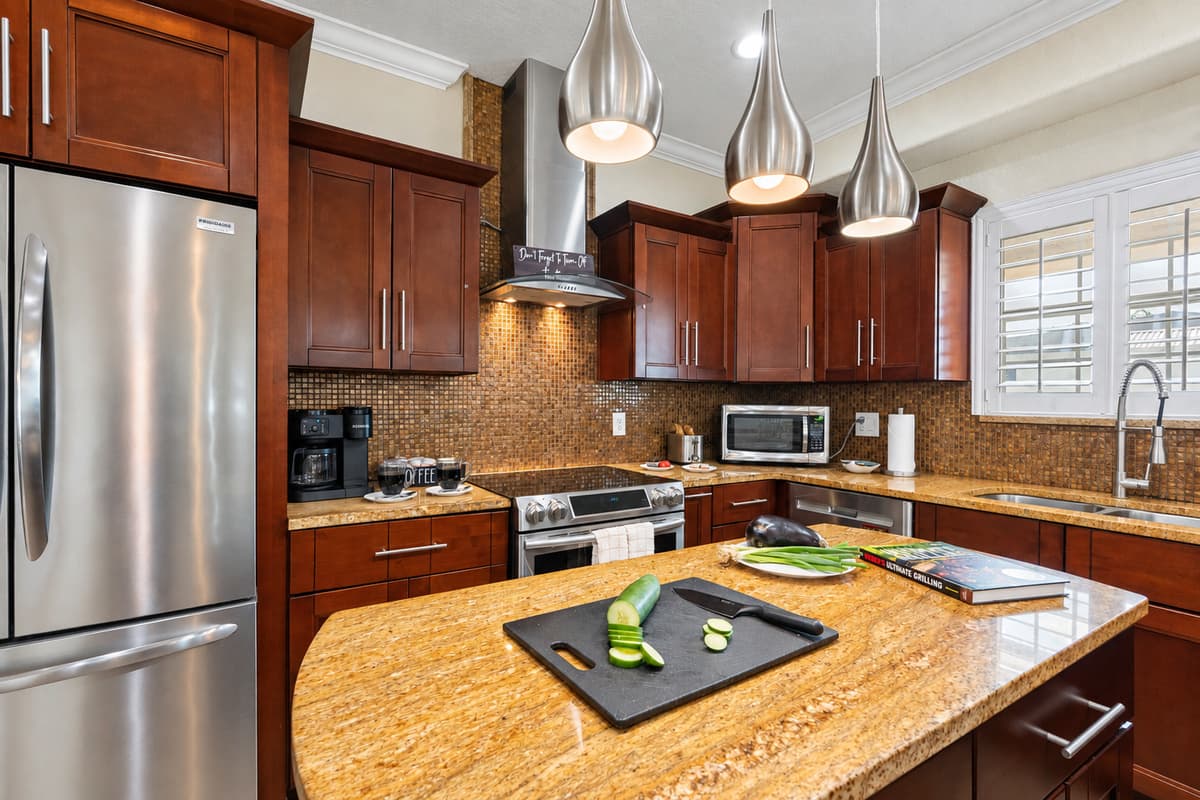 From the refrigerator to the range hood, stainless steel finishes complement the rich tones of the cabinetry and backsplash.