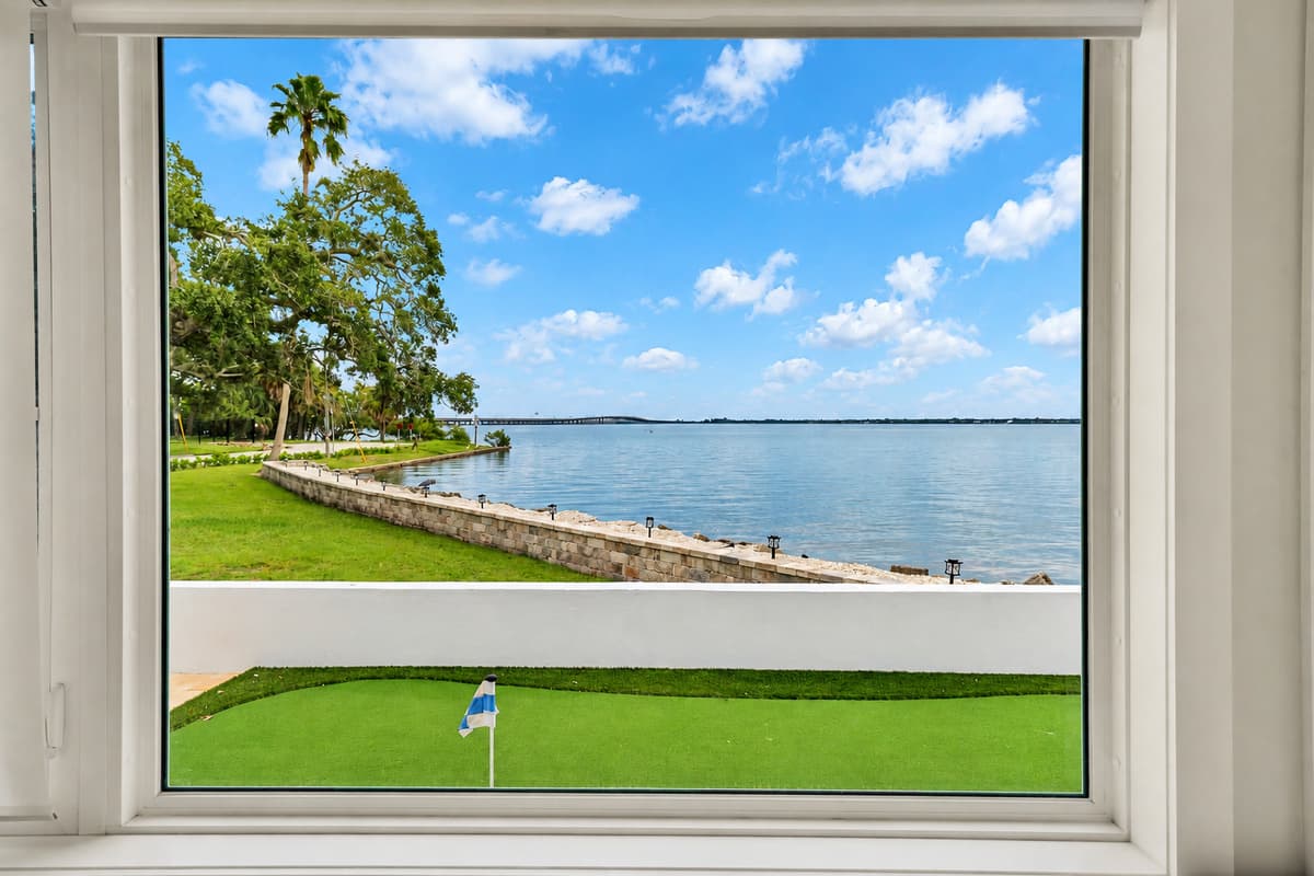 Look out: putting green, lawn, bay. Through the window you can see the putting green, the seawall and the open bay. A picture-perfect view from inside.