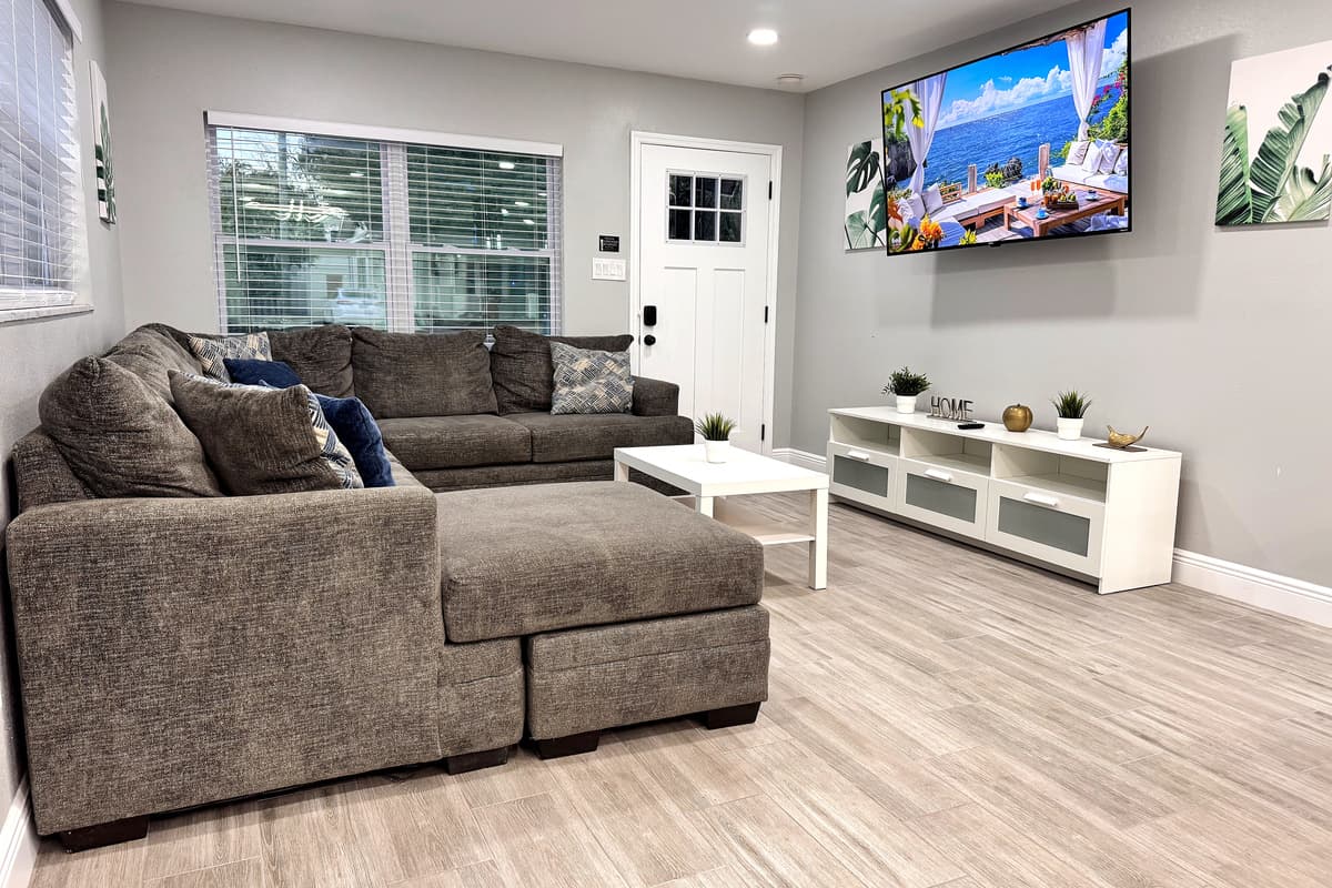 The decor in the living area is a blend of modern sophistication and cozy charm, featuring neutral tones, clean lines, and tasteful accents.