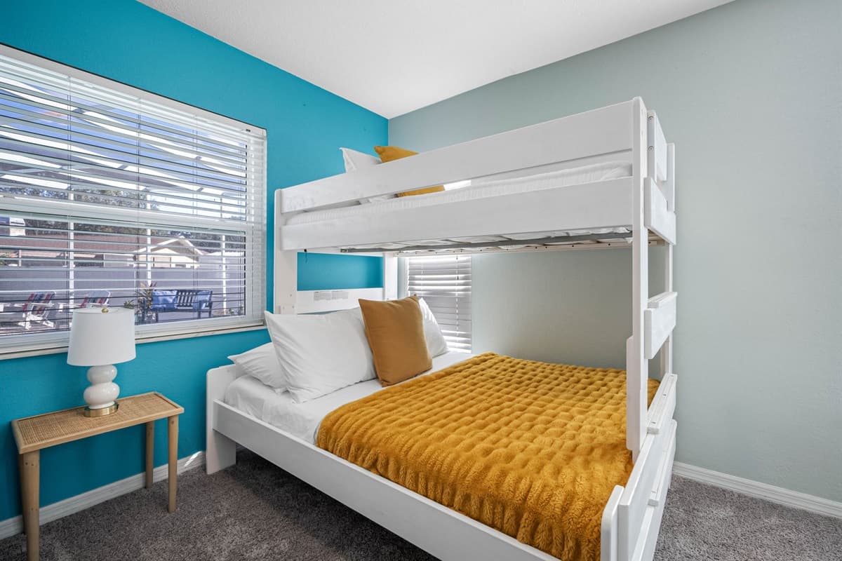 Designed with families in mind, this bunk room offers cozy beds and a fun pop of color for younger guests.