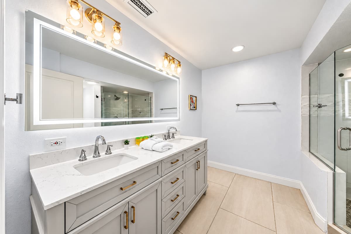 Luxurious double-sink vanity with oversized mirror and sleek modern lighting.