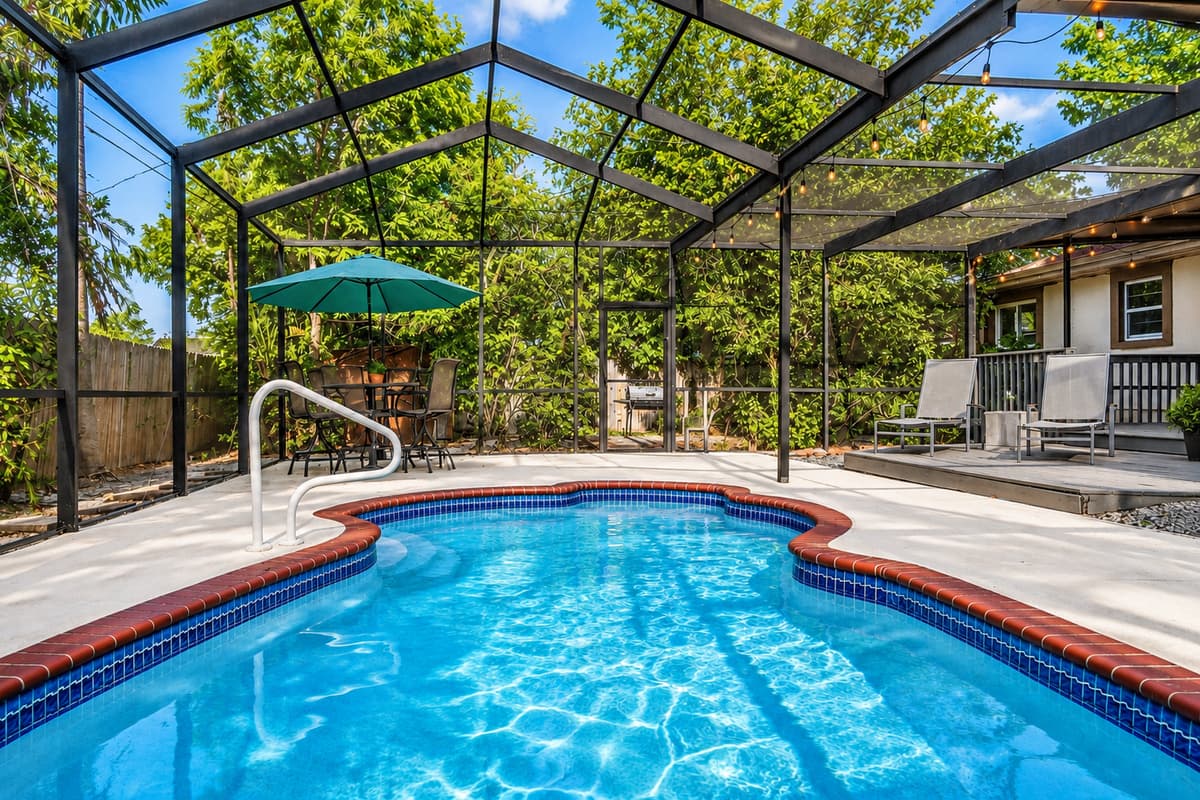Refreshing screened-in pool surrounded by lush greenery and plenty of outdoor seating.