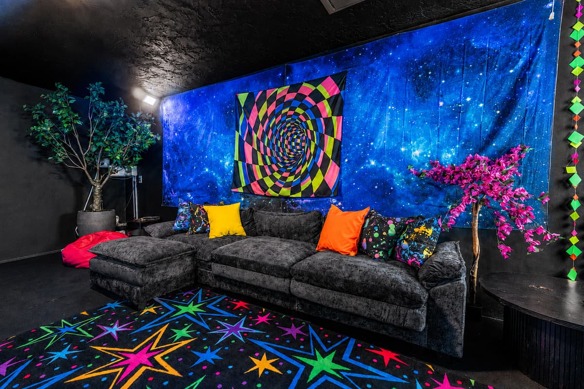 Sectional under the galaxy mural, bright pillows, star-print floor. Even the waiting area got designed.