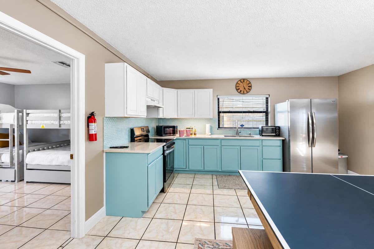 Soothing two-tone cabinetry in crisp white and soft seafoam green gives this kitchen a light, airy feel.