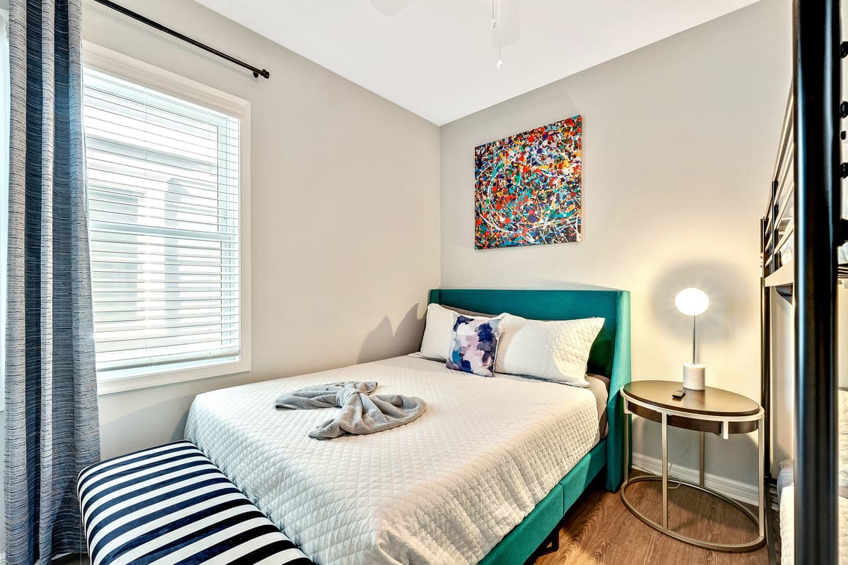 The queen-size bed provides a comfortable retreat, while the bunk bed introduces an element of fun and functionality.