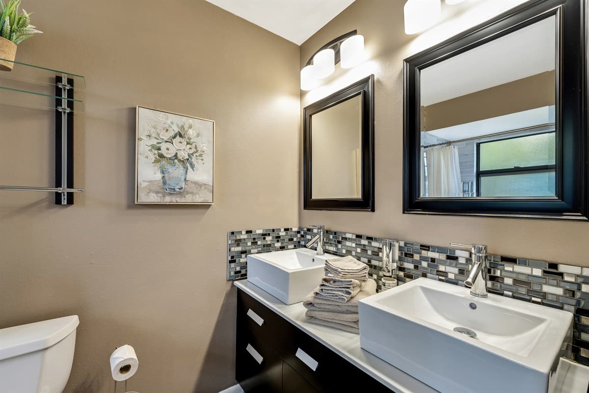 The sleek and contemporary design of the sink and vanity adds a touch of elegance to the bathroom, while also offering convenience and functionality.