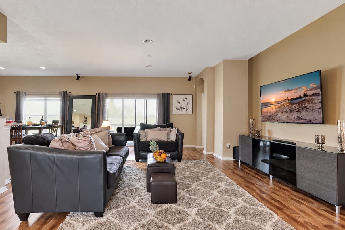 Oversized windows flood the room with natural light, offering sweeping views of the outdoors.