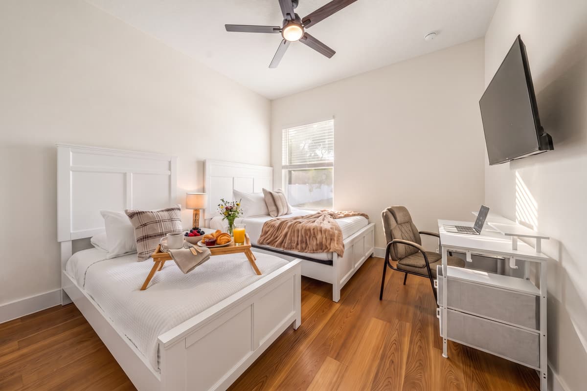 Flexible room for four: two beds, a TV for winding down, and a workspace for the mornings you can't skip.