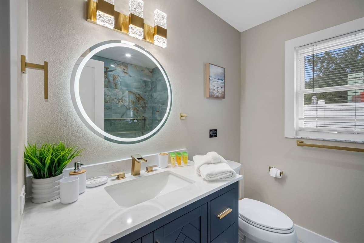 Enjoy the modern round LED mirror, marble countertop, and luxurious shower tiles that make every moment feel like a five-star experience.