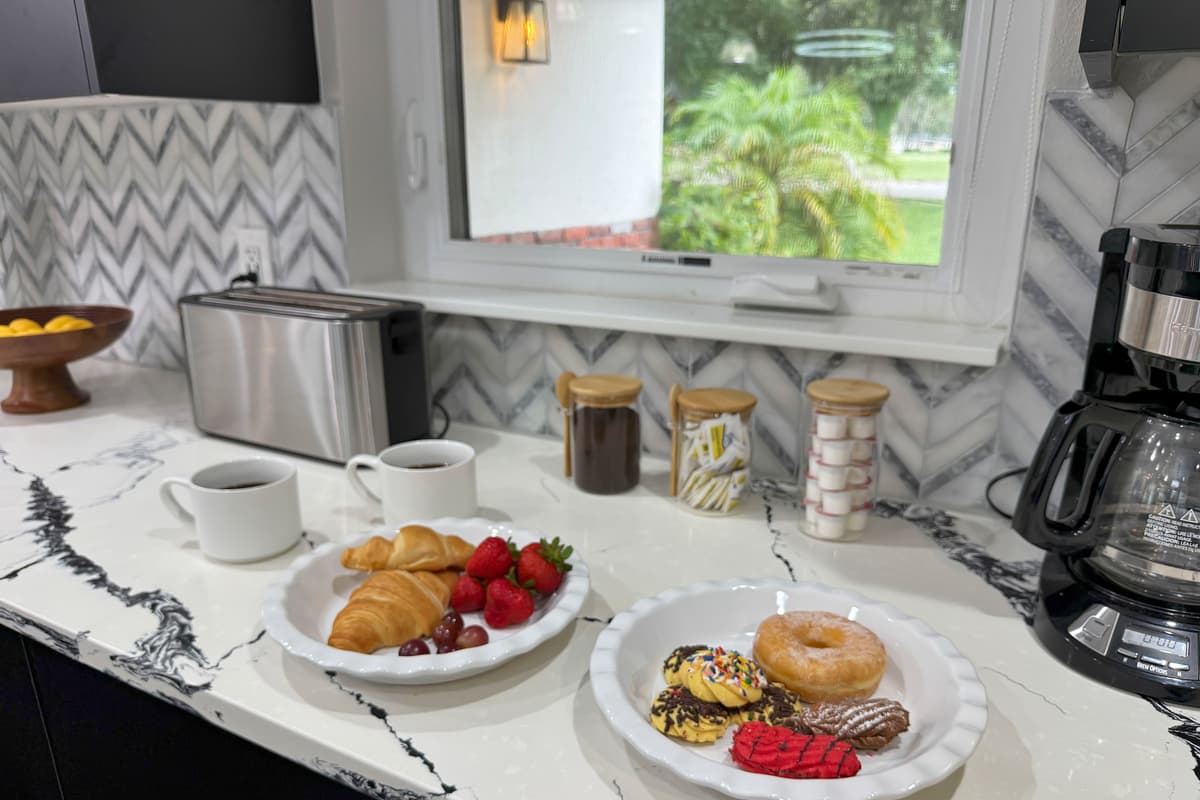 Croissants, fresh strawberries, coffee brewing, a window framed by palm trees — this is what "already on vacation" looks like at 8am.