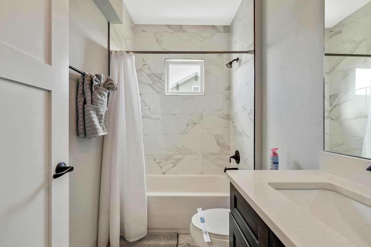 The spacious tub, inviting and deep, beckons you to immerse yourself in a cocoon of warmth and tranquility.