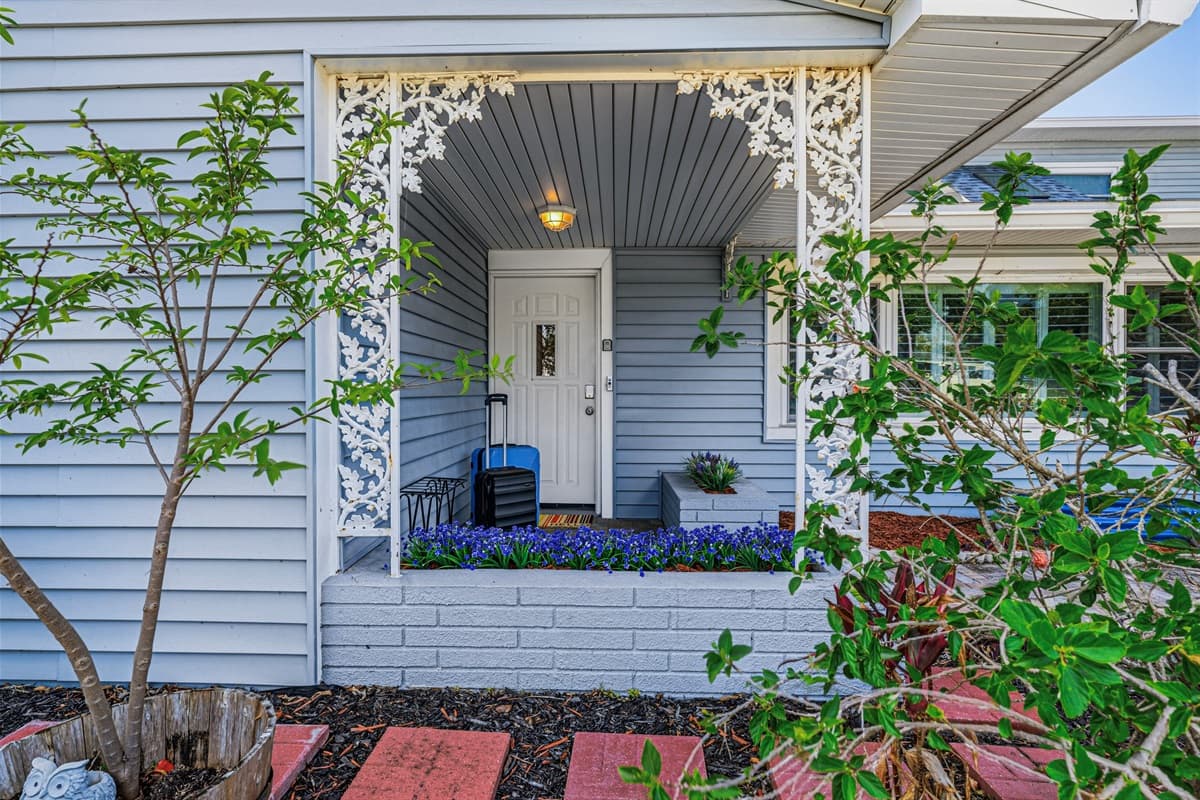 Charming front entrance with greenery and thoughtful landscaping—welcoming you to your stay 