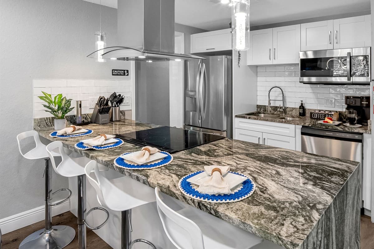 The large island doubles as a breakfast bar with seating for four — great for casual meals or socializing while you cook.