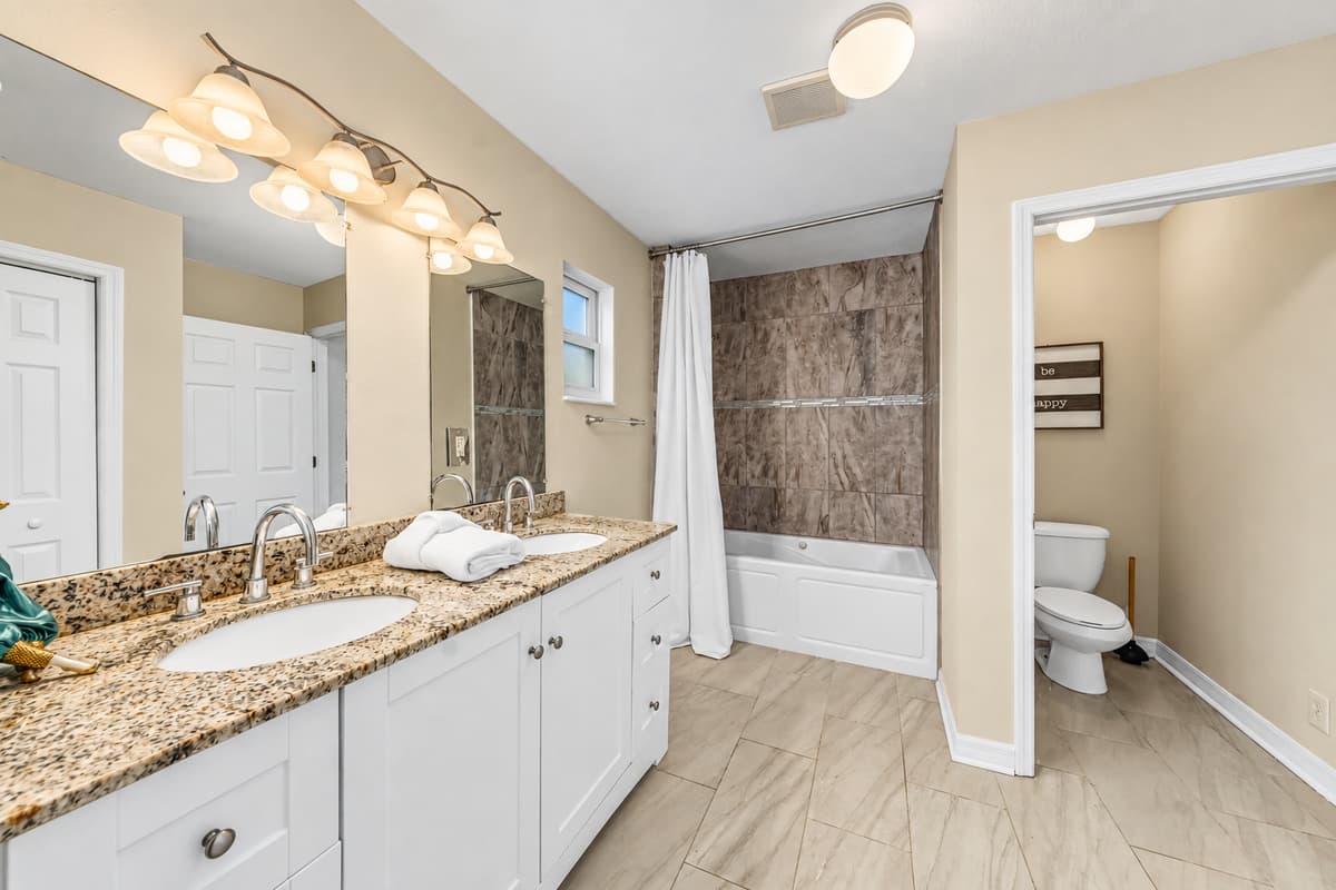 Spacious full bathroom with double vanity, ample counter space, and tub/shower combo.