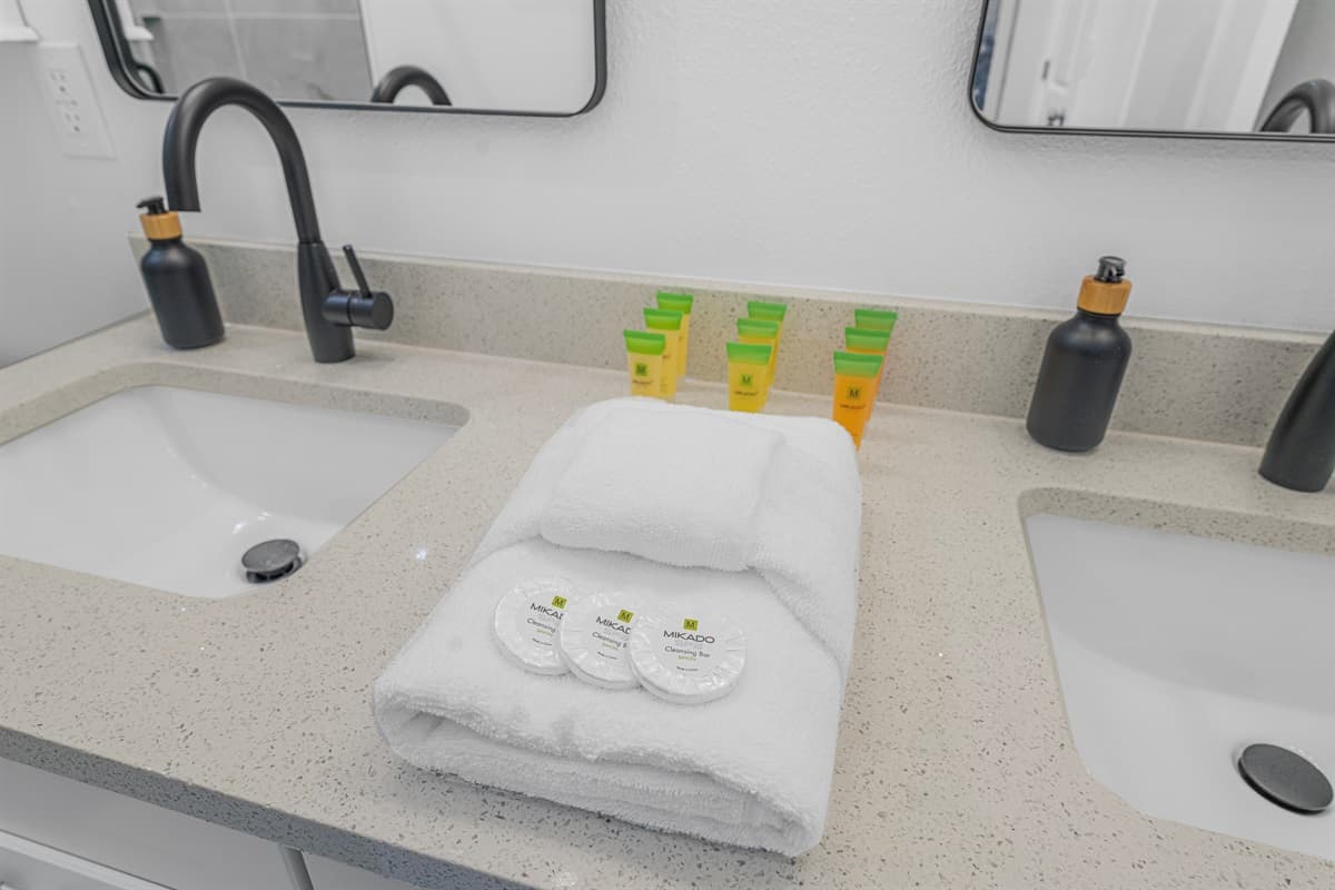 The bathroom sink area with fresh towels and complimentary toiletries for guests.